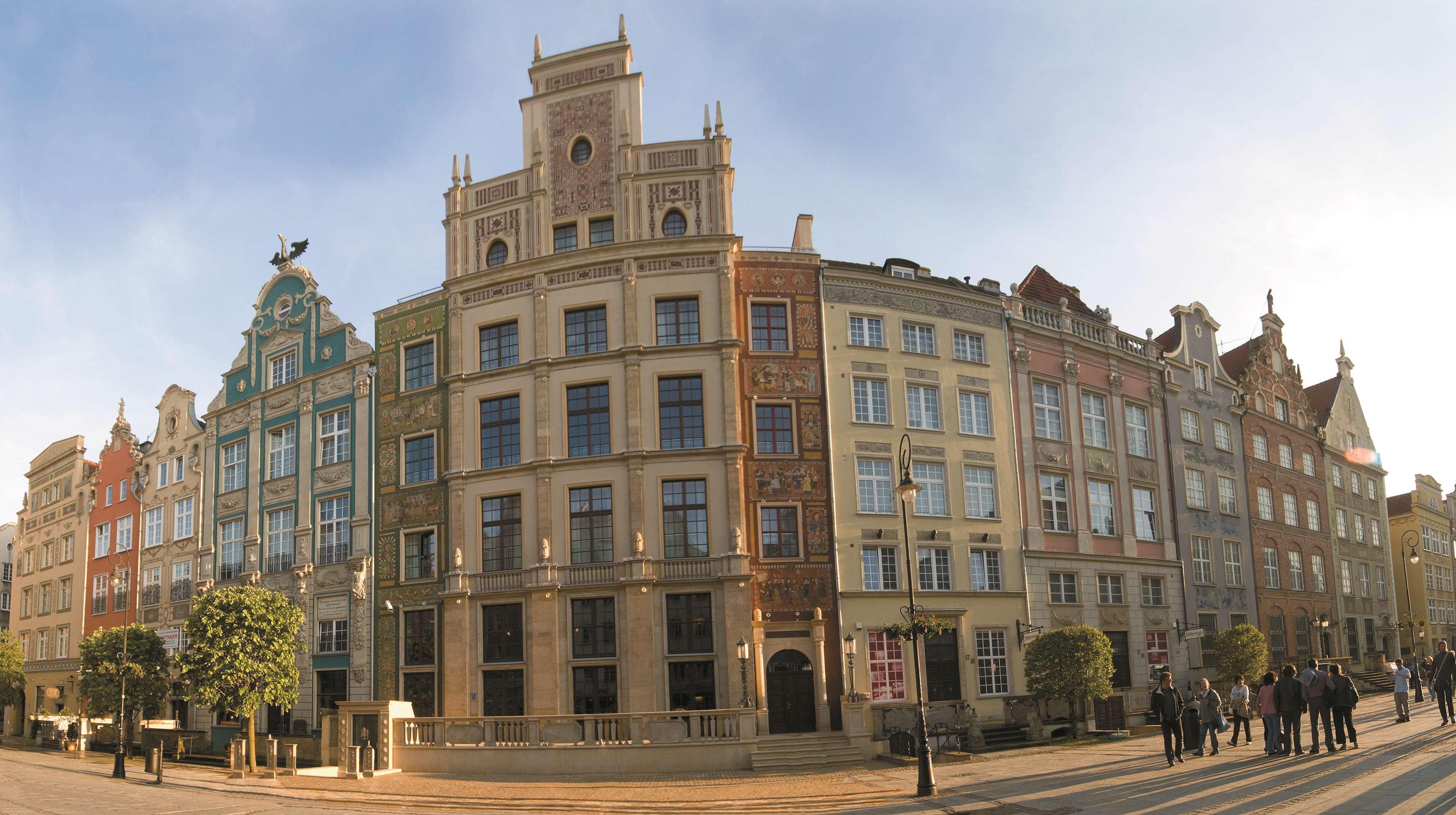 Radisson Blu Hotel, Гданск Екстериор снимка The photo showcases a panoramic view of a row of historic buildings, likely in a European city. The architecture features a blend of styles, presenting a vibrant facade with multiple colors and decorative elements. Each building has distinct characte