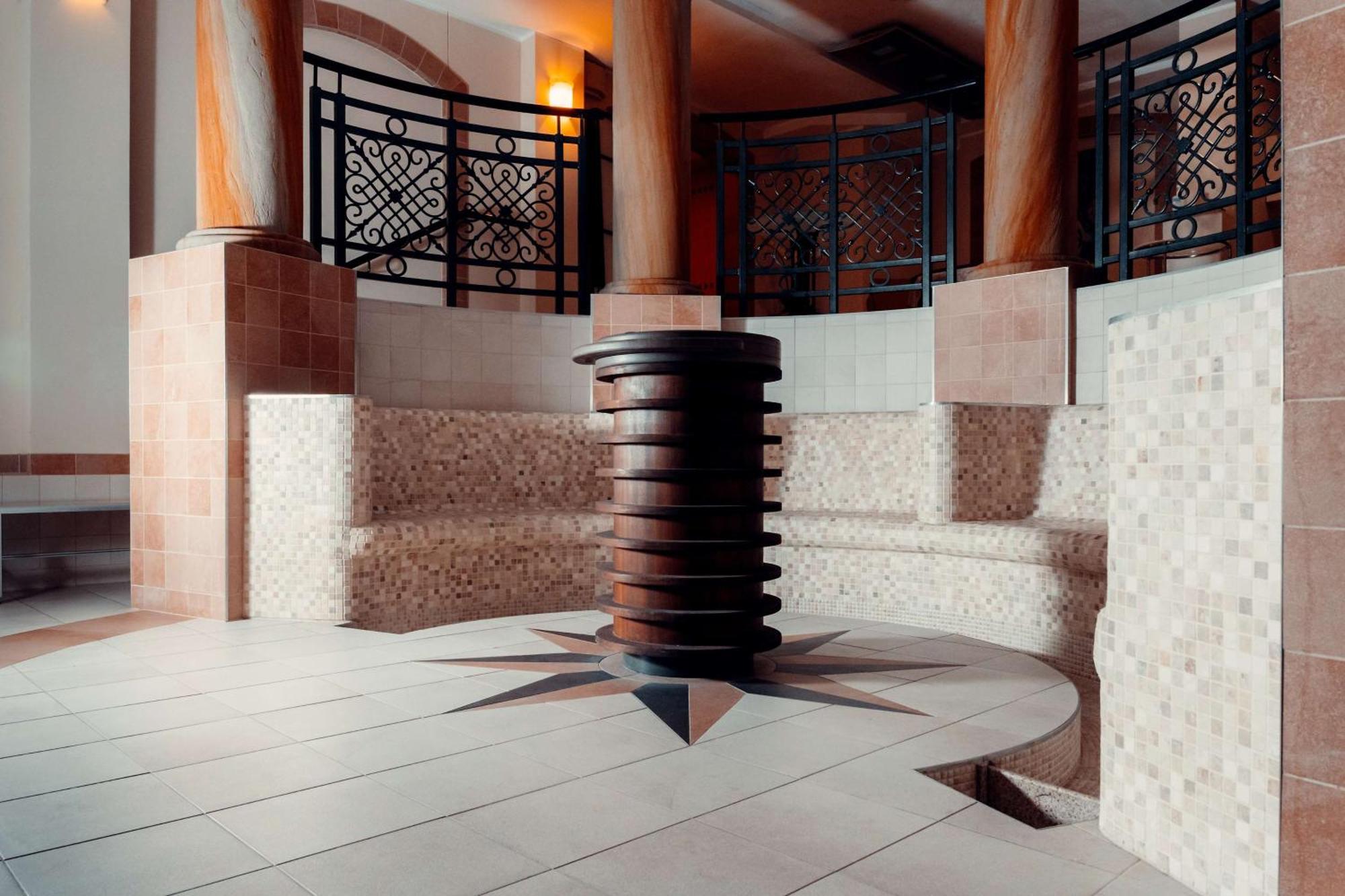 Radisson Blu Hotel, Гданск Екстериор снимка The photo showcases a well-designed interior space, likely part of a spa or wellness center. In the center, there is a circular seating area made of tiled blocks arranged in a semicircular pattern. The floor features a star-shaped design with contras
