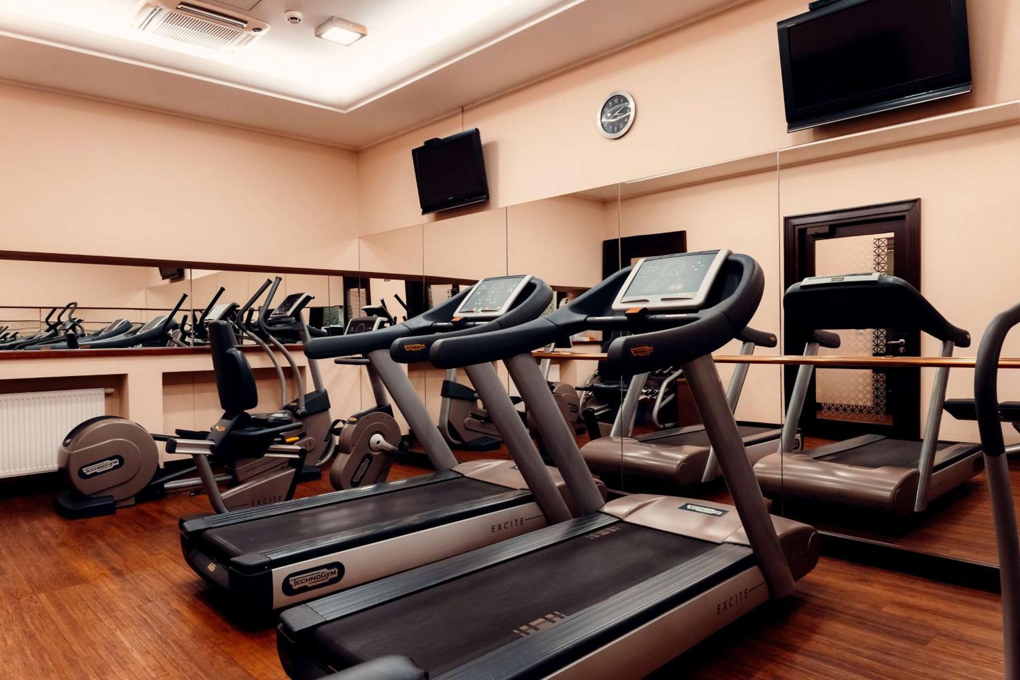 Radisson Blu Hotel, Гданск Екстериор снимка The photo shows a gym or fitness center with several exercise machines. There are multiple treadmills lined up in the foreground, each equipped with a display screen. In the background, there are additional fitness machines, including stationary bike