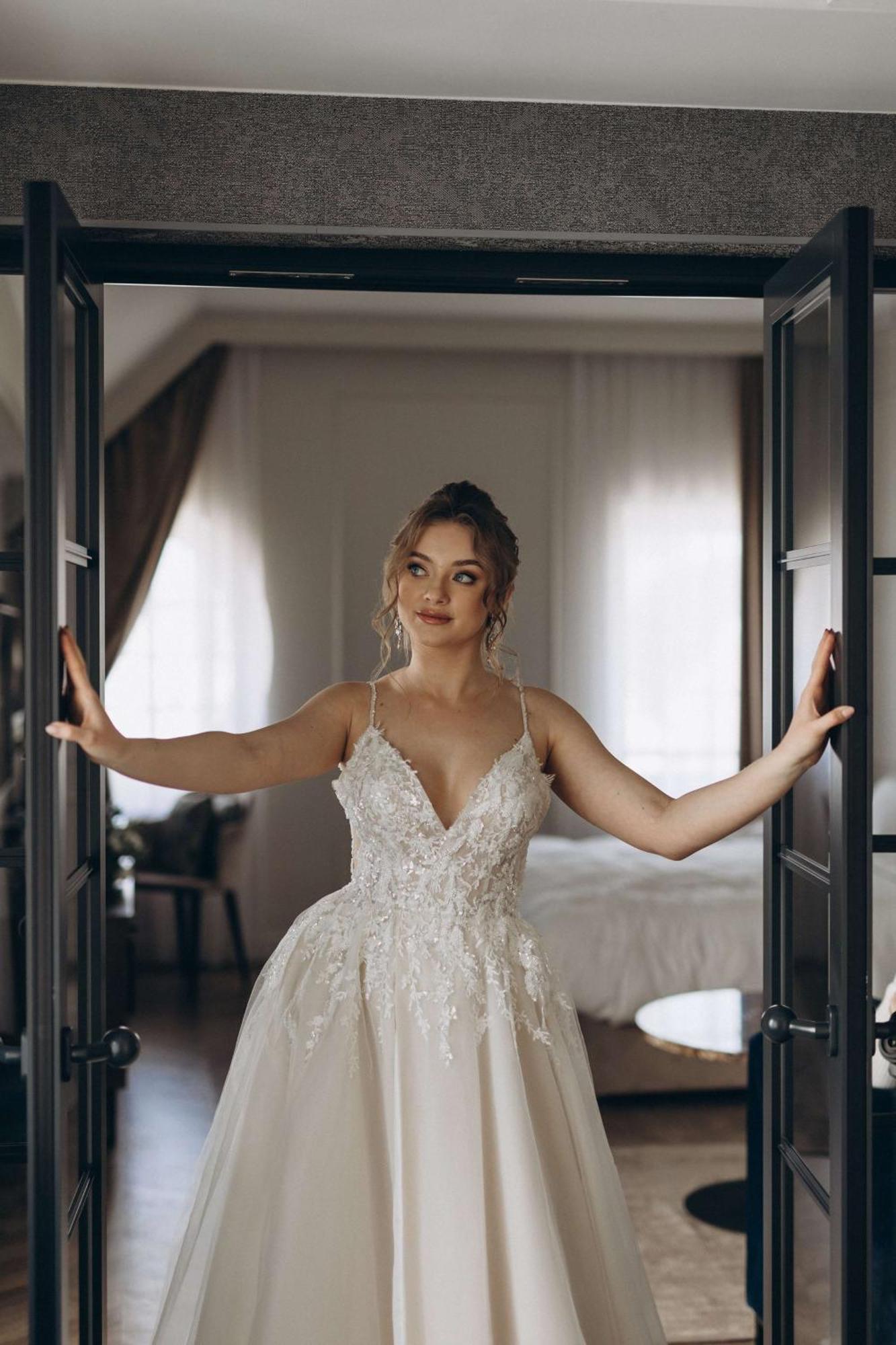 Radisson Blu Hotel, Гданск Екстериор снимка The photo shows a young woman standing between two open doors. She is wearing a beautiful wedding gown adorned with intricate details. Her hair is styled elegantly, and she has a thoughtful expression on her face. The setting appears to be a stylish 